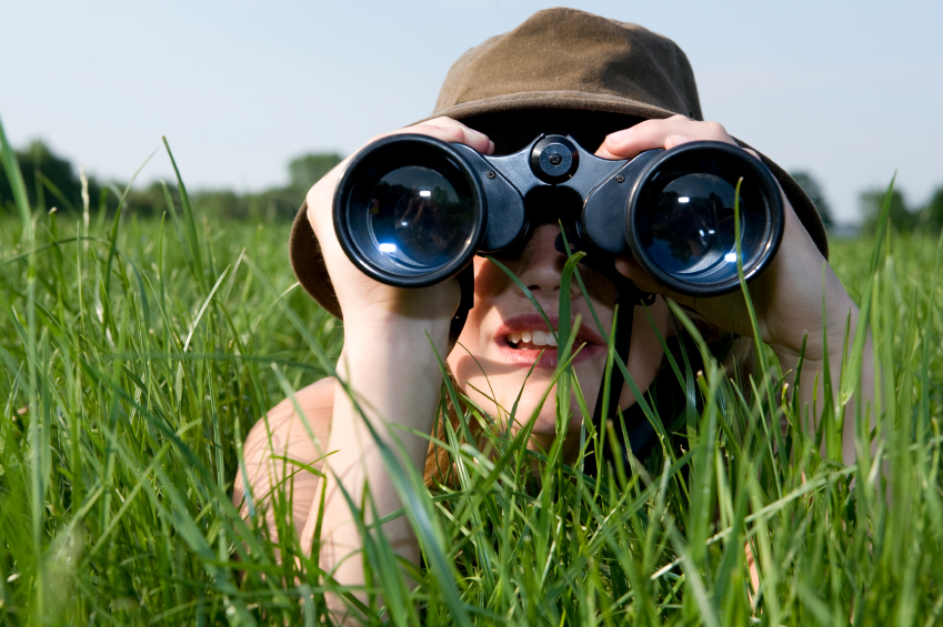 Image of a person looking through binoculars